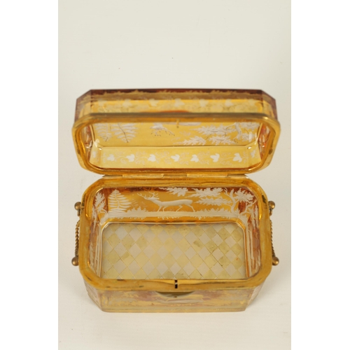 14 - A 19TH CENTURY BOHEMIAN AMBER GLASS OVERLAY CASKET with etched decoration depicting Stags amongst tr... 