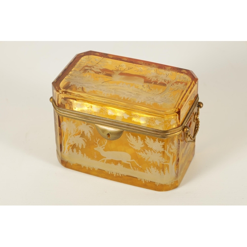 14 - A 19TH CENTURY BOHEMIAN AMBER GLASS OVERLAY CASKET with etched decoration depicting Stags amongst tr... 