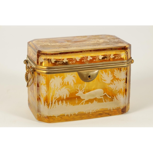 14 - A 19TH CENTURY BOHEMIAN AMBER GLASS OVERLAY CASKET with etched decoration depicting Stags amongst tr... 