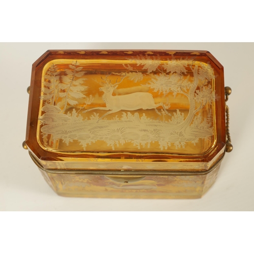 14 - A 19TH CENTURY BOHEMIAN AMBER GLASS OVERLAY CASKET with etched decoration depicting Stags amongst tr... 