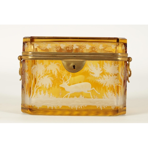 14 - A 19TH CENTURY BOHEMIAN AMBER GLASS OVERLAY CASKET with etched decoration depicting Stags amongst tr... 