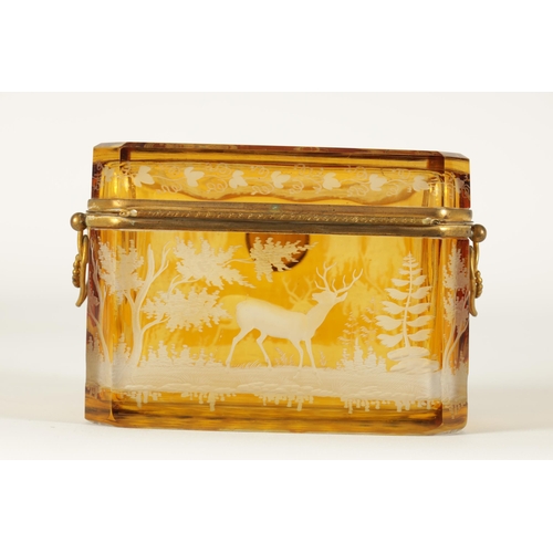 14 - A 19TH CENTURY BOHEMIAN AMBER GLASS OVERLAY CASKET with etched decoration depicting Stags amongst tr... 