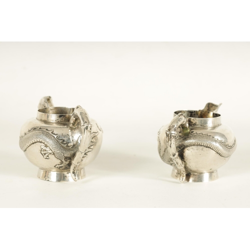 146 - A 19TH CENTURY CHINESE SILVER CREAM JUG AND SUGAR BOWL with bamboo handles and embossed swirling dra... 