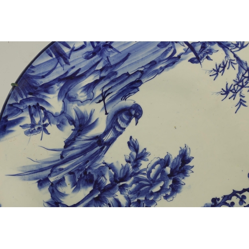 147 - A JAPANESE MEIJI PERIOD BLUE AND WHITE CHARGER with bird and tree decoration in a landscape setting.... 