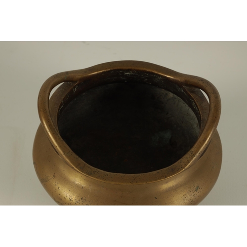 149 - A CHINESE CAST BRONZE SQUAT BULBOUS CENSER with shaped side handles and standing on three tapering f... 