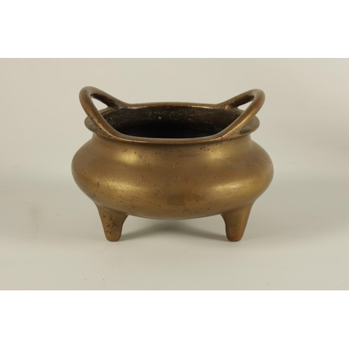 149 - A CHINESE CAST BRONZE SQUAT BULBOUS CENSER with shaped side handles and standing on three tapering f... 