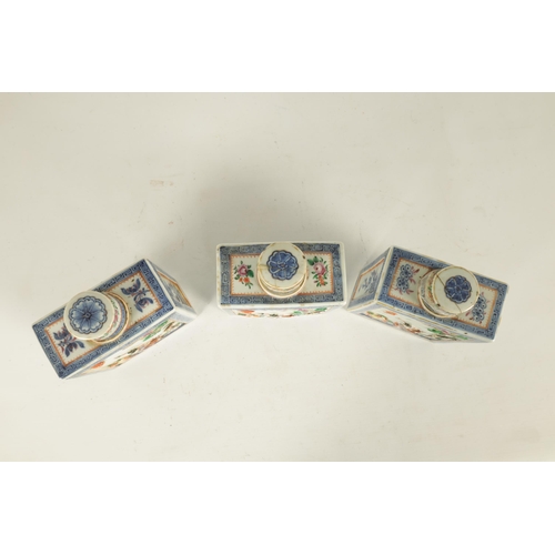 152 - A SET OF THREE 19TH CENTURY CHINESE FAMILLE ROSE PORCELAIN TEA CADDIES of rectangular form with cyli... 