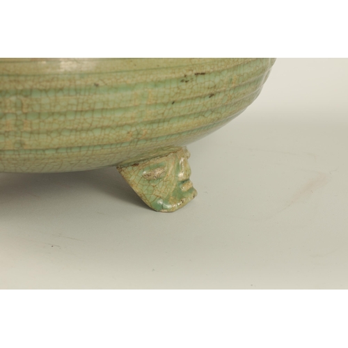 155 - AN EARLY CELADON MING DYNASTY TRIPOD BULB BOWL of ribbed outline, raised on a mask head tripod base.... 