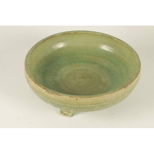 155 - AN EARLY CELADON MING DYNASTY TRIPOD BULB BOWL of ribbed outline, raised on a mask head tripod base.... 