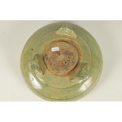 155 - AN EARLY CELADON MING DYNASTY TRIPOD BULB BOWL of ribbed outline, raised on a mask head tripod base.... 