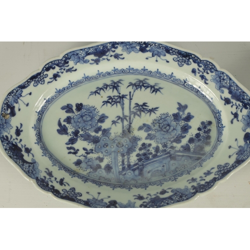 165 - A PAIR OF 18TH CENTURY CHINESE BLUE AND WHITE SHAPED OVAL DISHES with floral landscape centres and b... 