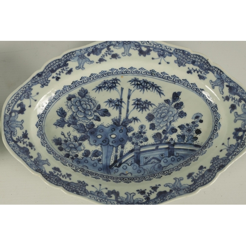 165 - A PAIR OF 18TH CENTURY CHINESE BLUE AND WHITE SHAPED OVAL DISHES with floral landscape centres and b... 