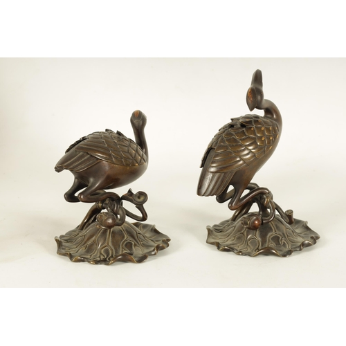 167 - A PAIR OF JAPANESE MEIJI PERIOD BRONZE AND GOLD INLAID CENSERS modelled as perched cranes with lift ... 