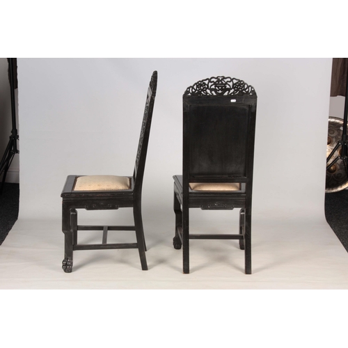 202 - A PAIR OF CHINESE HARDWOOD CHAIRS with carved pierced top rails above carved panelled backs and pad ... 