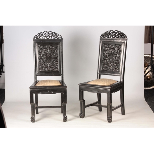 205 - A PAIR OF CHINESE HARDWOOD CHAIRS with carved pierced top rails above carved panelled backs and pad ... 