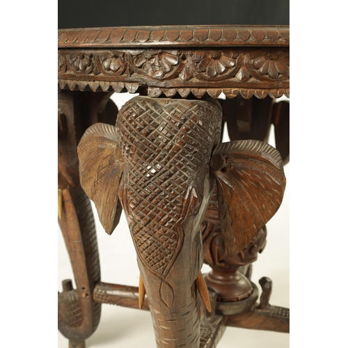 216 - A LATE 19TH CENTURY CARVED INDIAN 'ELEPHANT' TABLE having a carved oval top supported on four legs f... 