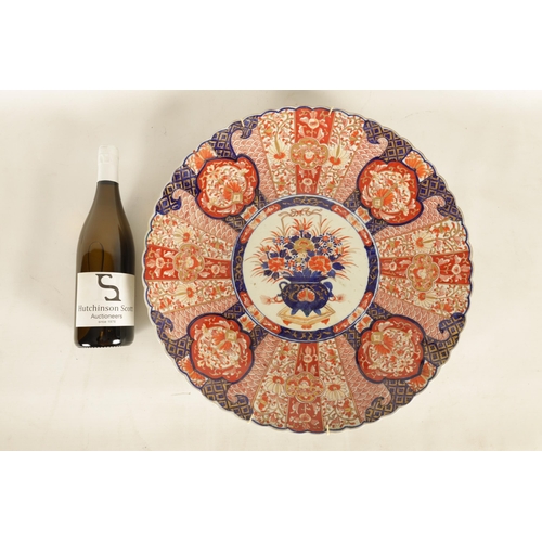 219 - A 19TH CENTURY IMARI CHARGER with fluted border decorated brightly coloured floral designs high-ligh... 