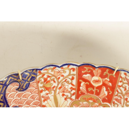 219 - A 19TH CENTURY IMARI CHARGER with fluted border decorated brightly coloured floral designs high-ligh... 