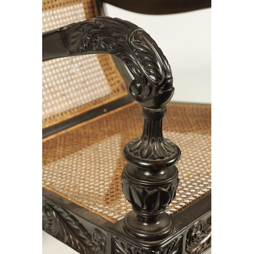 227 - AN IMPRESSIVE LATE REGENCY ANGLO INDIAN CARVED EBONY BERGERE OPEN ARMCHAIR OF GENEROUS SIZE with mou... 