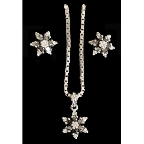 283 - A SET OF VINTAGE 9CT WHITE GOLD BLACK DIAMOND NECKLACE AND EARRINGS with six-point stars on a square... 