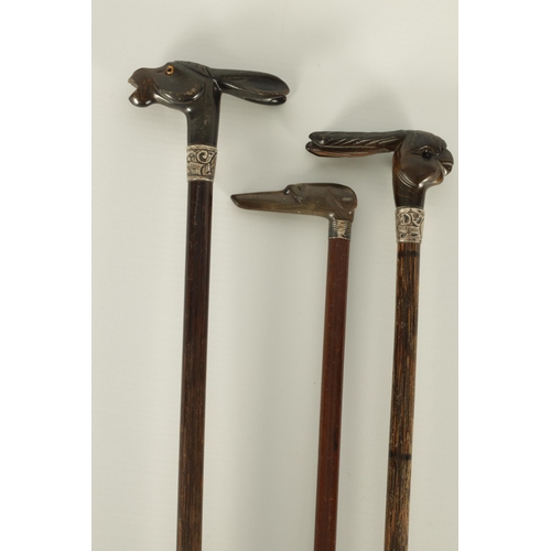 431 - A SELECTION OF THREE RHINOCEROS HORN HANDLED WALKING STICKS depicting a donkey, dog and parrot, moun... 