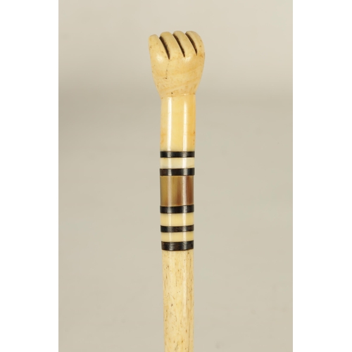 439 - A 19TH CENTURY WHALEBONE AND BALEEN BANDED WALKING STICK with sailors fist handle and tapering shaft... 