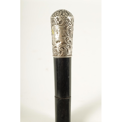 443 - A LATE 19TH CENTURY SILVER MOUNTED EBONISED SWORD STICK having a foliate and scrollwork embossed sil... 