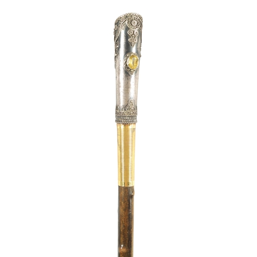 449 - AN EARLY 20TH CENTURY RHINOCEROS HORN SWAGGER STICK having a jewelled silvered metal handle with sil... 