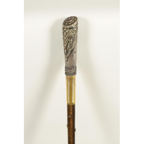 449 - AN EARLY 20TH CENTURY RHINOCEROS HORN SWAGGER STICK having a jewelled silvered metal handle with sil... 