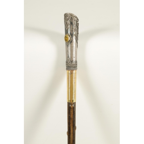 449 - AN EARLY 20TH CENTURY RHINOCEROS HORN SWAGGER STICK having a jewelled silvered metal handle with sil... 