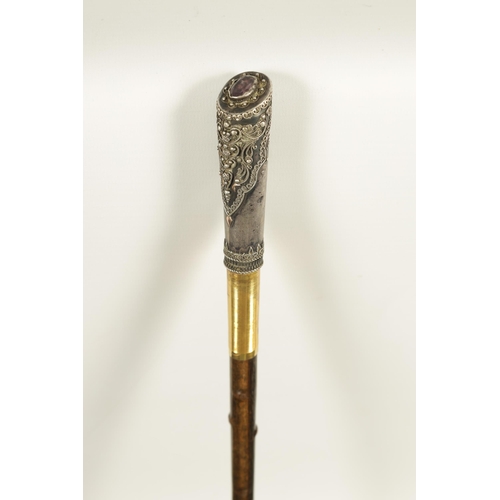 449 - AN EARLY 20TH CENTURY RHINOCEROS HORN SWAGGER STICK having a jewelled silvered metal handle with sil... 