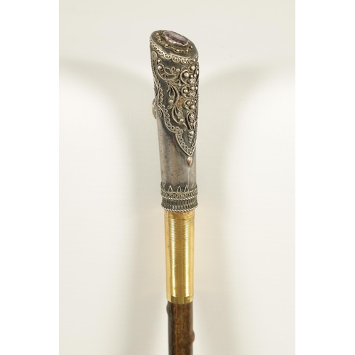 449 - AN EARLY 20TH CENTURY RHINOCEROS HORN SWAGGER STICK having a jewelled silvered metal handle with sil... 