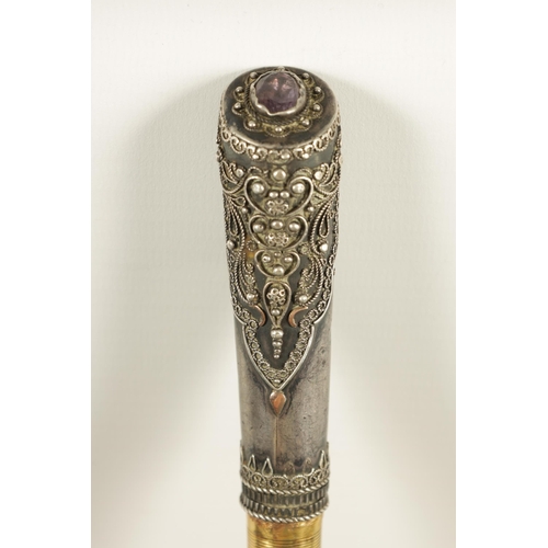 449 - AN EARLY 20TH CENTURY RHINOCEROS HORN SWAGGER STICK having a jewelled silvered metal handle with sil... 