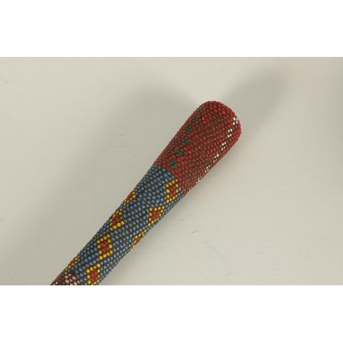 466 - A LATE 19TH CENTURY ZULU COLOURED BEADWORK WALKING CANE decorated multi geometric panels. (65cm over... 