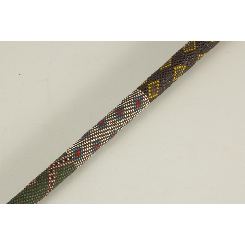 466 - A LATE 19TH CENTURY ZULU COLOURED BEADWORK WALKING CANE decorated multi geometric panels. (65cm over... 