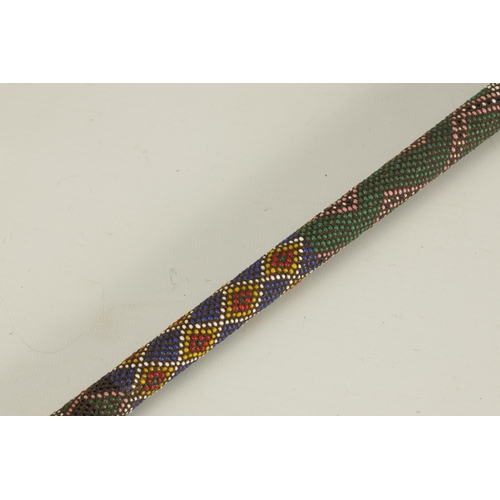 466 - A LATE 19TH CENTURY ZULU COLOURED BEADWORK WALKING CANE decorated multi geometric panels. (65cm over... 