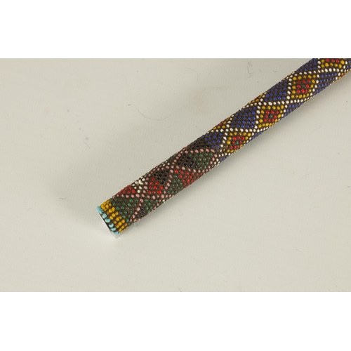 466 - A LATE 19TH CENTURY ZULU COLOURED BEADWORK WALKING CANE decorated multi geometric panels. (65cm over... 