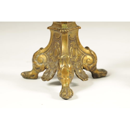 501 - A SET OF FOUR 18TH CENTURY CONTINENTAL LARGE BRASS CANDLESTICKS with cast leaf scrolled tripod bases... 