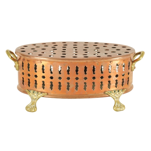 512 - AN UNUSUAL 19TH CENTURY BRASS AND COPPER TWO-HANDLED PIERCED OVAL FOOT WARMER raised on cast scrolle... 