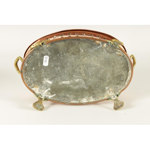 512 - AN UNUSUAL 19TH CENTURY BRASS AND COPPER TWO-HANDLED PIERCED OVAL FOOT WARMER raised on cast scrolle... 