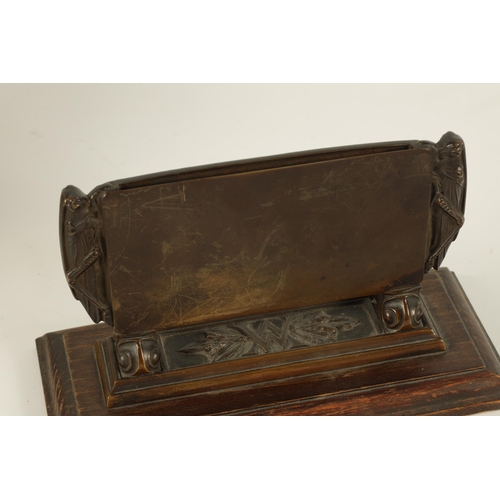 528 - A STYLISH ARTS AND CRAFTS BRONZE CARD DISPLAY STAND the moulded frame with locust sides on leaf cast... 