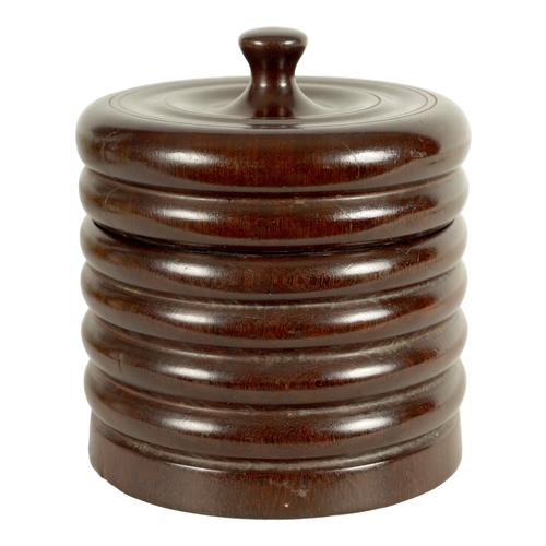 551 - A 19TH CENTURY TREENWARE LIGNUM VITAE CIRCULAR BOX AND COVER of ribbed form with ringed dished top a... 