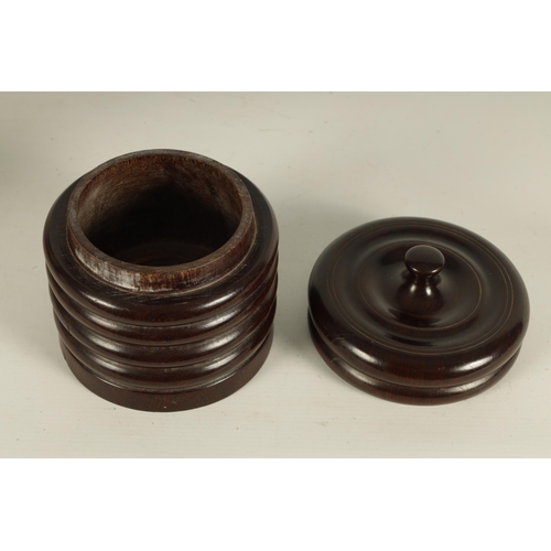 551 - A 19TH CENTURY TREENWARE LIGNUM VITAE CIRCULAR BOX AND COVER of ribbed form with ringed dished top a... 