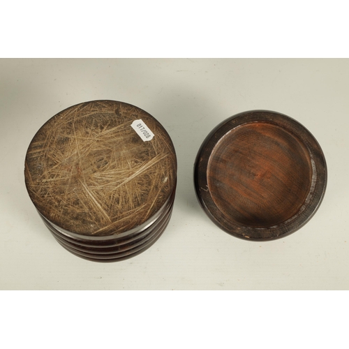 551 - A 19TH CENTURY TREENWARE LIGNUM VITAE CIRCULAR BOX AND COVER of ribbed form with ringed dished top a... 