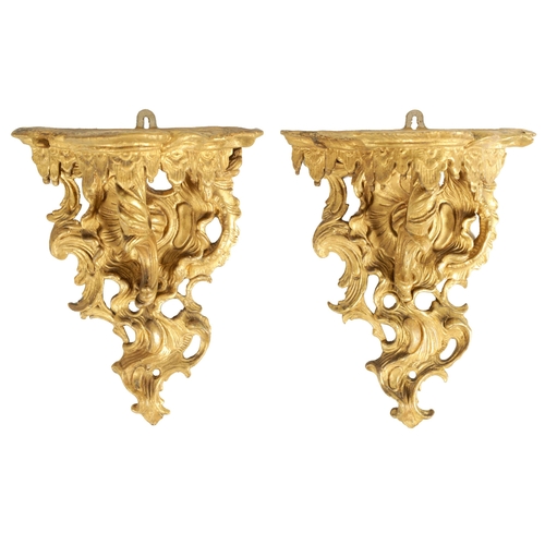 552 - A PAIR OF EARLY GEORGE III CARVED GILTWOOD WALL BRACKETS of scrollwork rococo design. (34cm high, 27... 