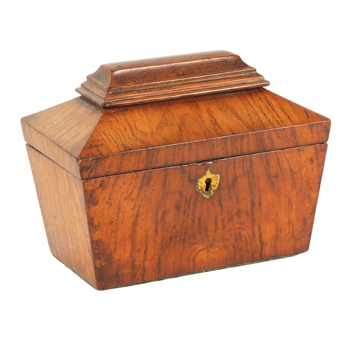 555 - A LATE REGENCY FIGURED OAK SARCOPHAGUS SHAPED TEA CADDY with inlaid burr maple lidded divided interi... 