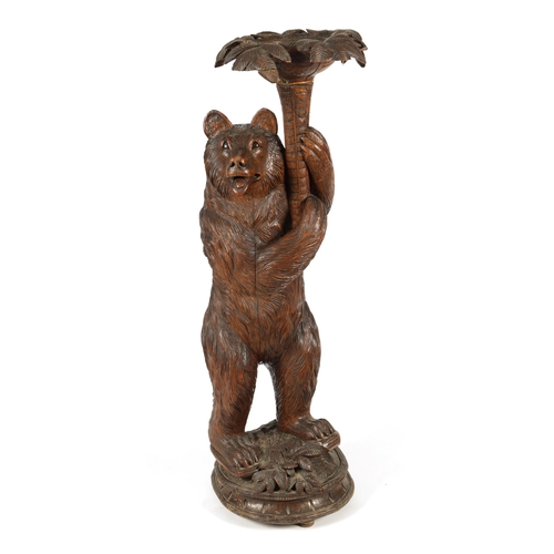 558 - A LATE 19TH CENTURY CARVED BLACK FOREST BEAR JARDINIERE STAND inset with glass and holding a palm tr... 