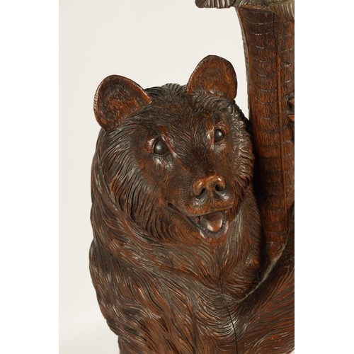 558 - A LATE 19TH CENTURY CARVED BLACK FOREST BEAR JARDINIERE STAND inset with glass and holding a palm tr... 