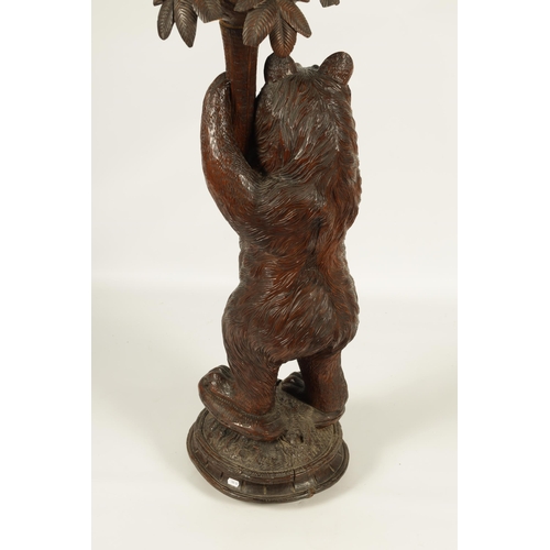 558 - A LATE 19TH CENTURY CARVED BLACK FOREST BEAR JARDINIERE STAND inset with glass and holding a palm tr... 