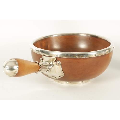 581 - A LATE 19TH CENTURY SILVER MOUNTED FRUITWOOD BOWL having a silver riveted rim and base with turned h... 